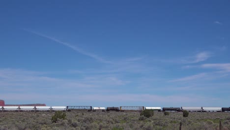 una vista artística de un tren de carga que pasa por el desierto de arizona o nuevo méxico