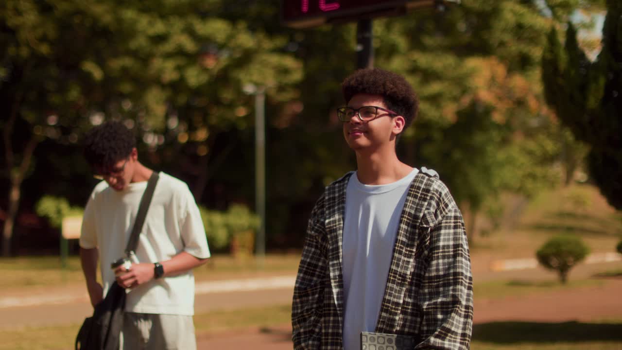 Two Young Men Enjoying a Sunny Day Outdoors on a Campus or Park