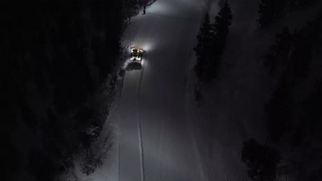 aerial of snow machine at work in idre, sweden during a late evening in the dark-2