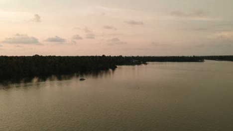 beautiful aerial shot of a backwater vembanadu lake,water lines,twilight sunset,coconut trees ,water transportation,clouds,reflation,house boat,red sky