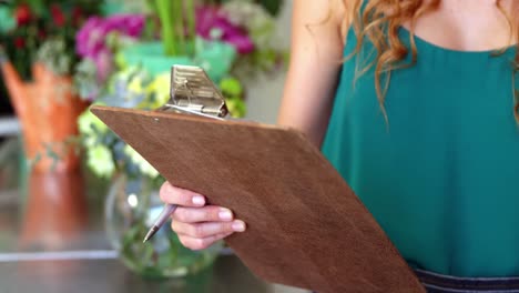 florista mujer tomando un pedido en el teléfono móvil