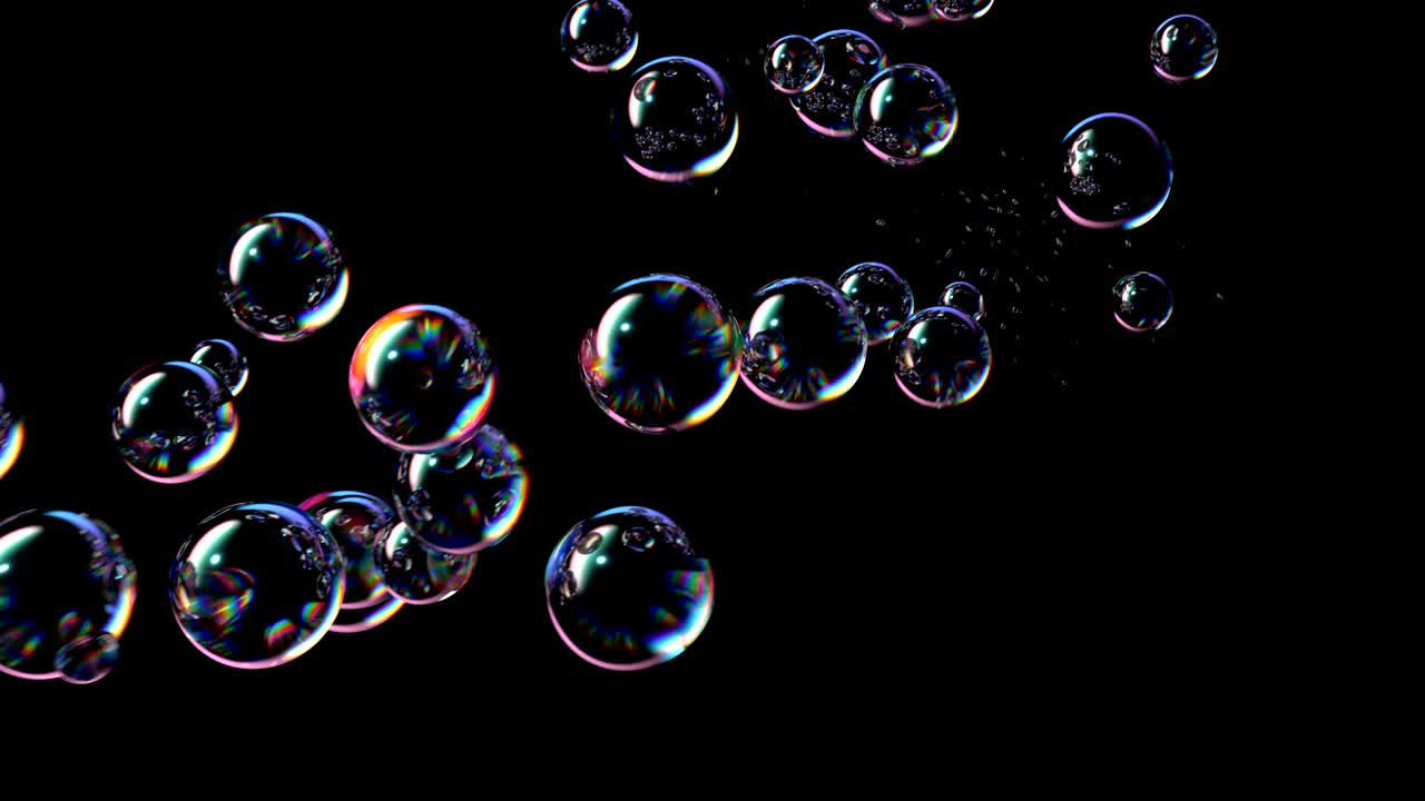 las burbujas de jabón vuelan y estallan sobre un fondo negro