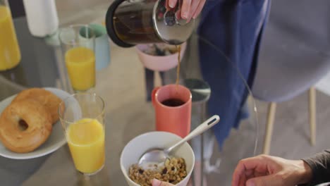 Sección-Media-De-Una-Mujer-Caucásica-Sirviendo-Café-En-Una-Taza-En-Casa