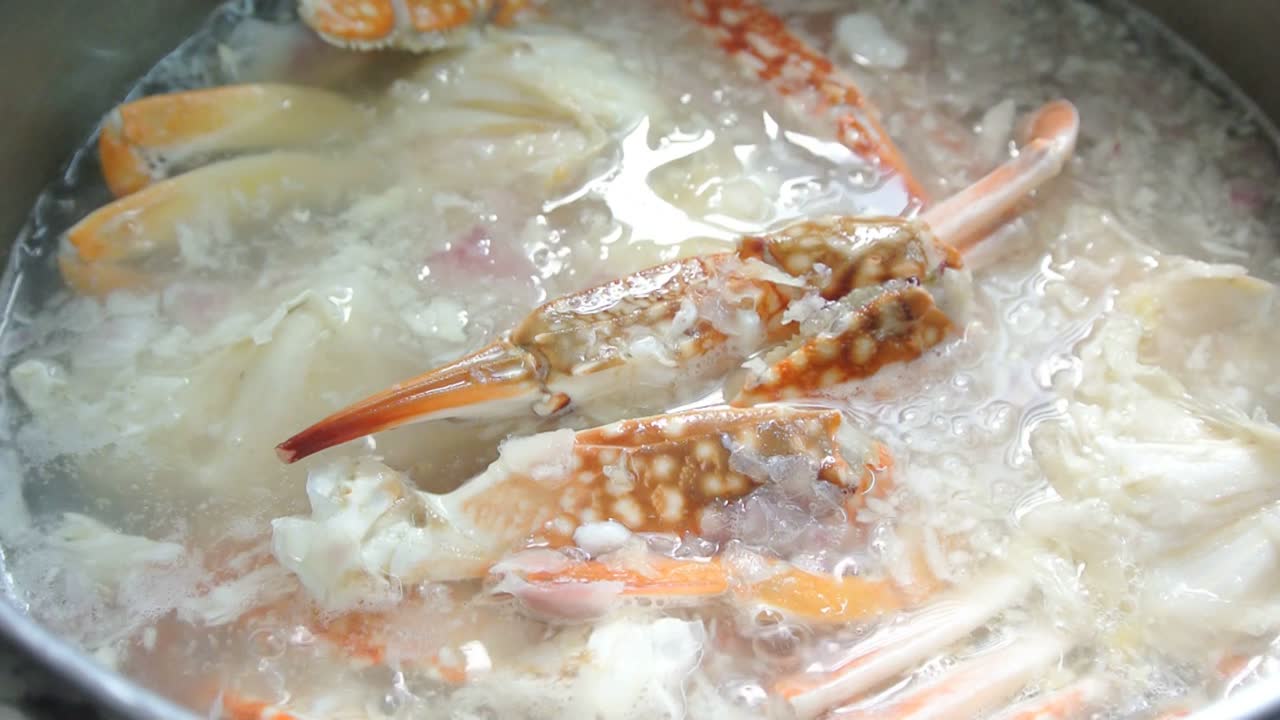 The cooks cook crab soup. Crab soup is cooked in a saucepan and stirred slowly for cooking evenly. Cooking ingredients included in stages