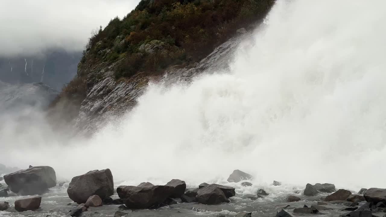 Toma panorámica en mano del inmenso y potente flujo de agua en la base de las cataratas Nugget cerca de Juneau, Alaska. 4K