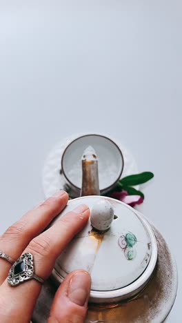hand holding teapot lid