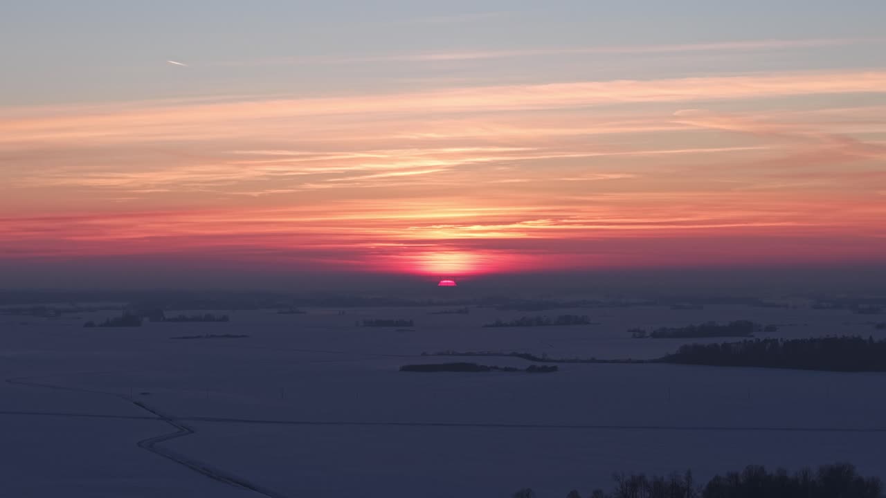 雪で覆われた地平線と空に広がる冬の夕焼けの色、空撮ハイパーラプスプルバック