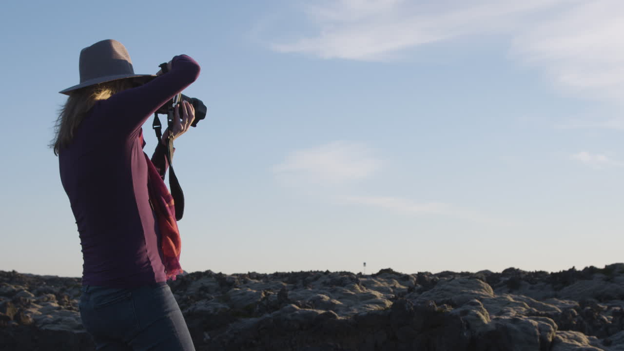 mujer embarazada fotógrafa y videógrafa filmando en islandia