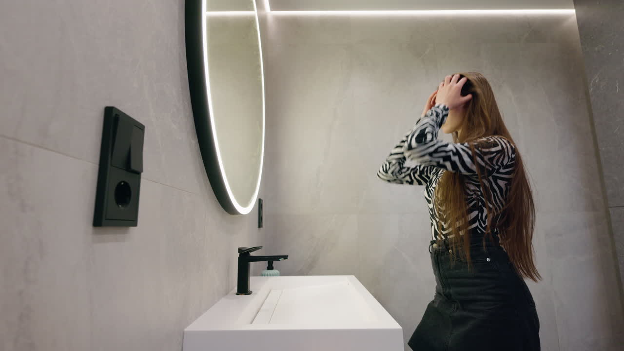Woman Styling Hair in Modern Bathroom