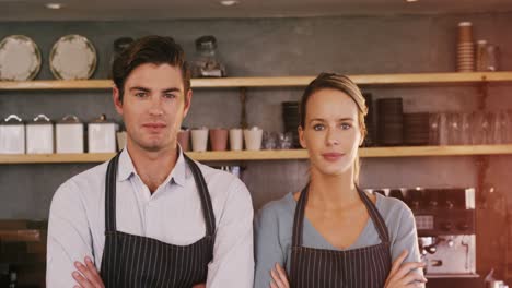 waiter and waitress standing with their arms crossed