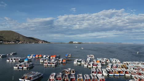 aerial rises over boats moored in puno, peru harbour on lake titicaca