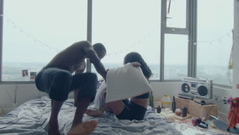 young couple fighting with pillows in bedroom