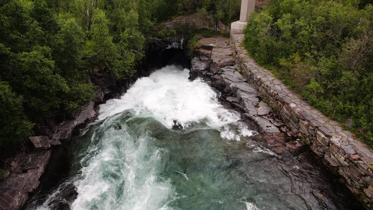 Wild powerful river flowing under the bridge, tilt up