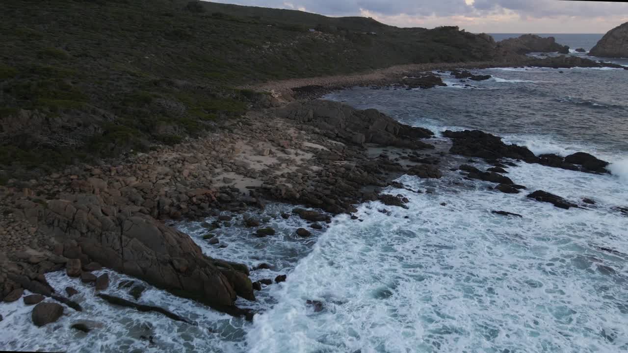 Riprese aeree dinamiche che si muovono lungo le coste con varie onde che si infrangono sulla riva