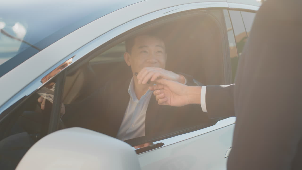 hombre asiático conduciendo un coche eléctrico