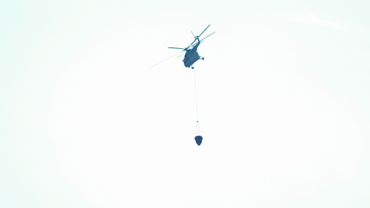 산불 물통을 끌 준비가 된 헬리콥터