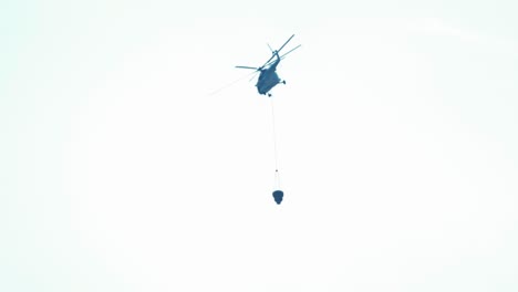 helicóptero listo para apagar el cubo de agua de incendios forestales