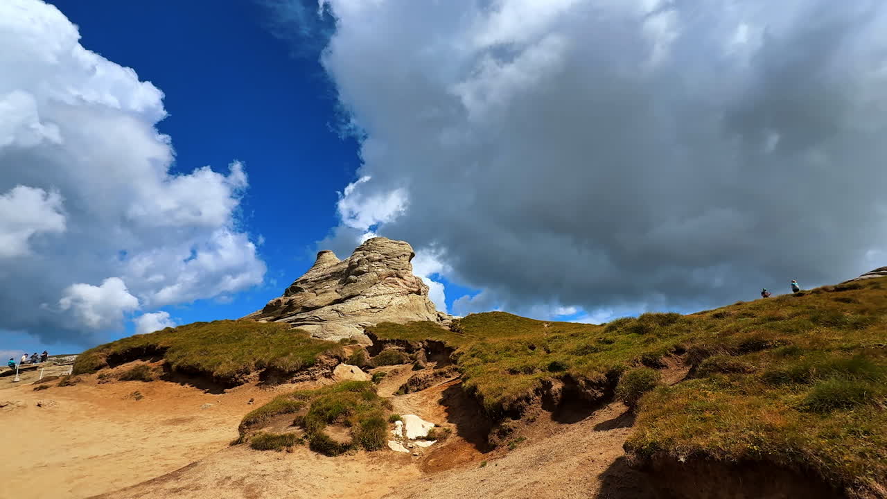 Whimsical rock at the mountain top. Low angle view. Hiking in the Bucegi Mountains of the Southern Carpathians, Romania
