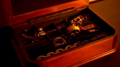 opening a box of gold jewelry in an atmospheric shot, elegant and classy