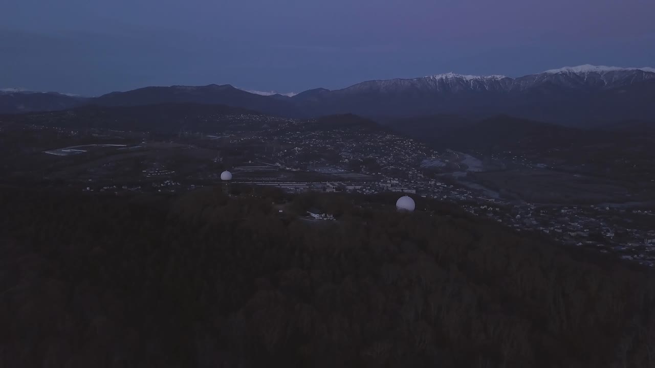 воздушный вид долины в сумерках с радарными тарелками на вершине холма