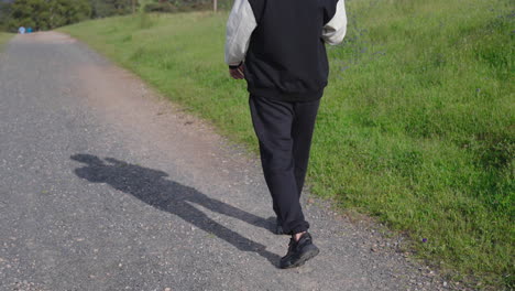 indian sikh man walking downhill and using his phone - close up on feet