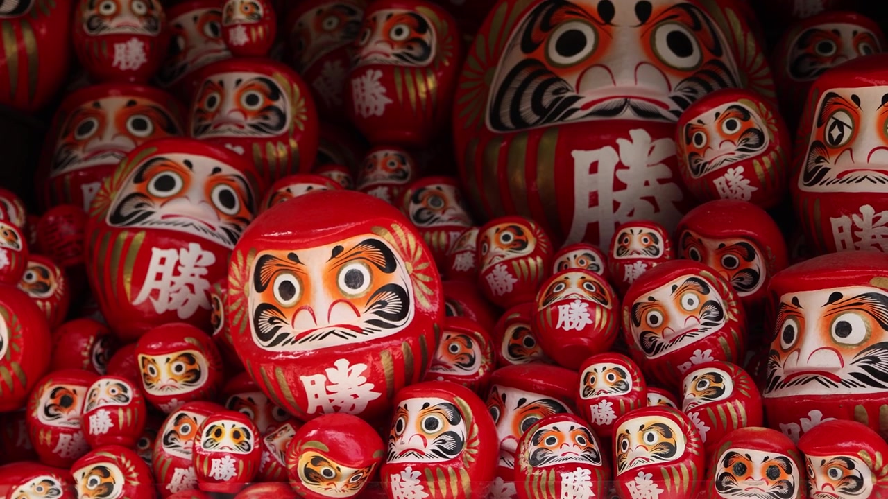 Vista ravvicinata di numerose bambole Daruma rosse esposte al tempio Katsuo-ji a Minoh, Osaka, Giappone, un tempio buddista famoso come simbolo di buona fortuna, perseveranza e vittoria