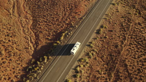 topdown drone aerial footage of rv driving along road on american road trip in the desert, near canyonlands national park, utah
