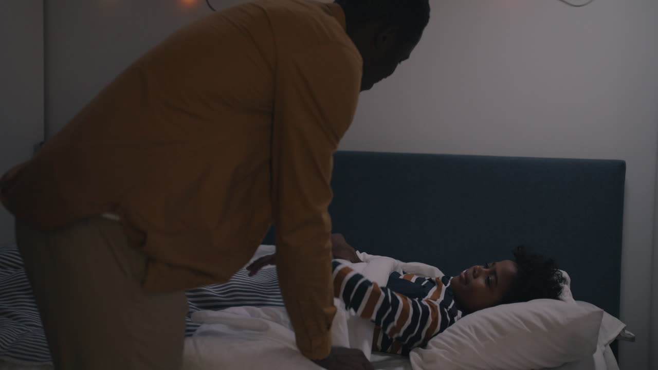 Father putting his daughter to bed