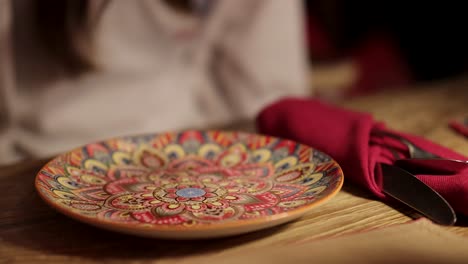 vibrant plate and cutlery set on a wooden table in a bangkok restaurant, captured with warm lighting and a cozy atmosphere