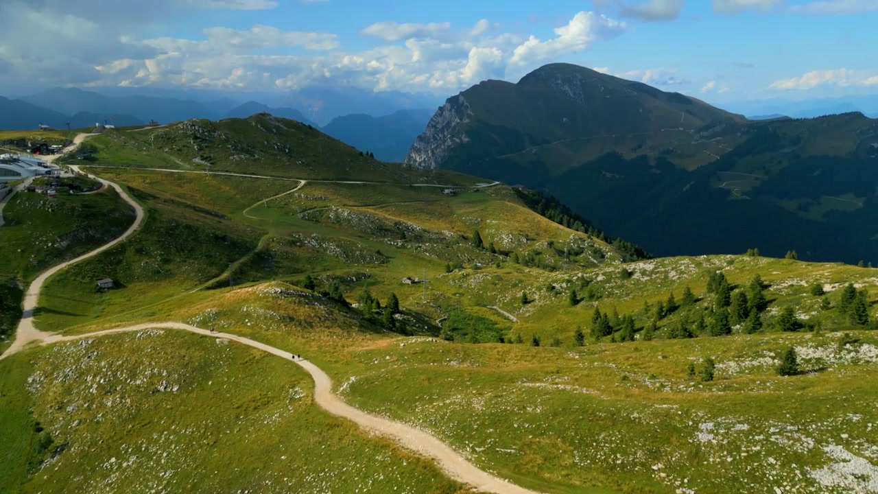 Vista aerea di pecore al pascolo sui pendii erbosi del Monte Baldo, sentieri tortuosi e montagne