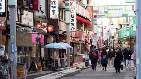 pedestrians walking down a vibrant japanese street