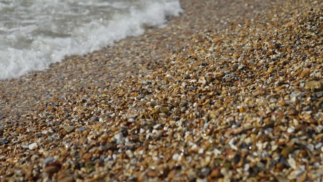 파도가 해변의 자갈에 부 ⁇ 히며