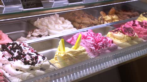 freezer display case of several varieties of gourmet ice cream on sale in ice cream shop