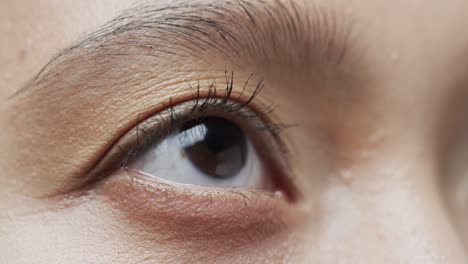 close up of eye of asian woman with dark hair, slow motion