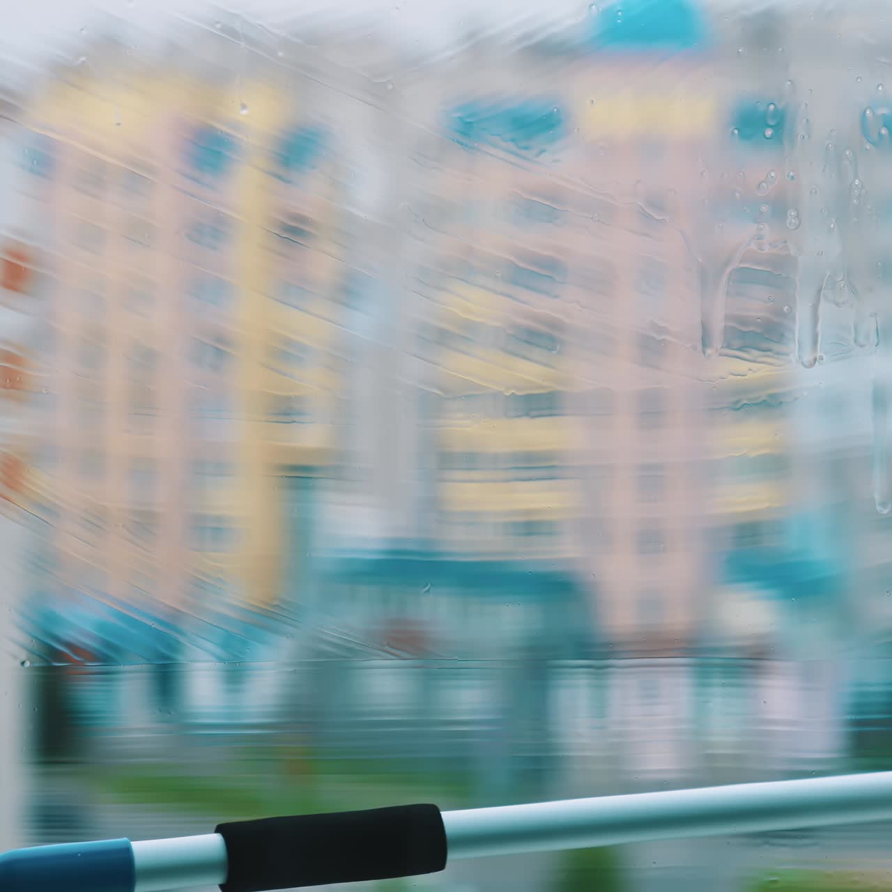 Window is cleaning with brush. Washing glass with clean water by special tool inside the flat. Professional window cleaning service. Close-up