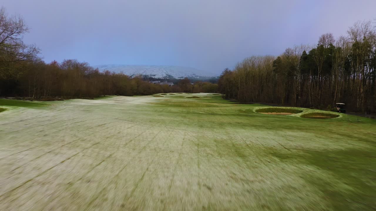 Snow-Covered Winter Golf Course Landscape with Distant Mountains
