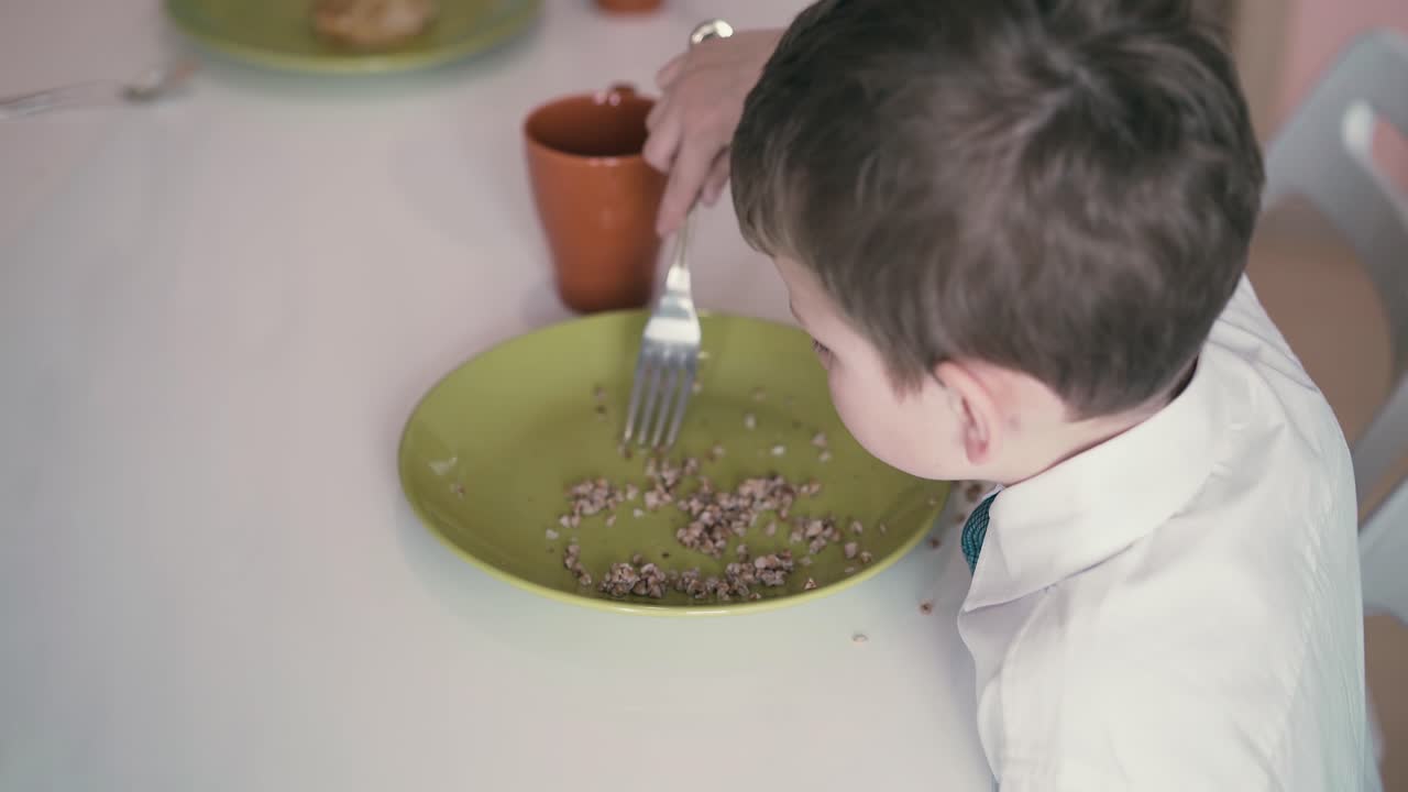 Bambino in uniforme scolastica fa colazione prima di andare a scuola 2.