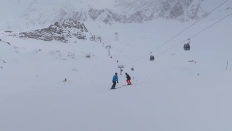 滑雪者在阿尔卑斯山的滑雪<unk>上骑着云<unk>的山坡 - - 全景