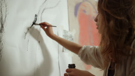 female painter creating artwork on wall with kids