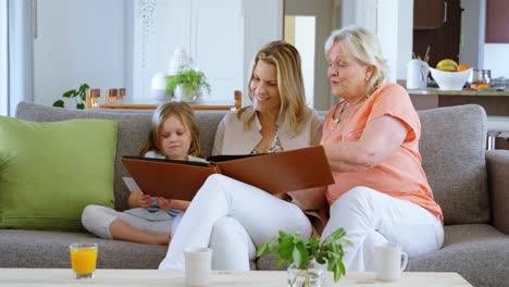 family looking photo album in living room 4k