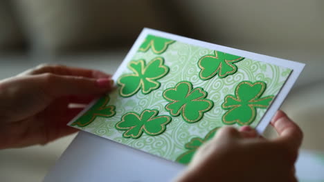 person holding a handmade st. patrick's day greeting card with shamrocks