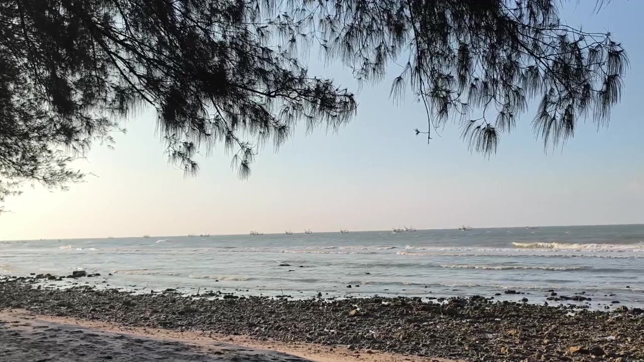 Scenic View of Ocean Waves and Fishing Boats at Sunset