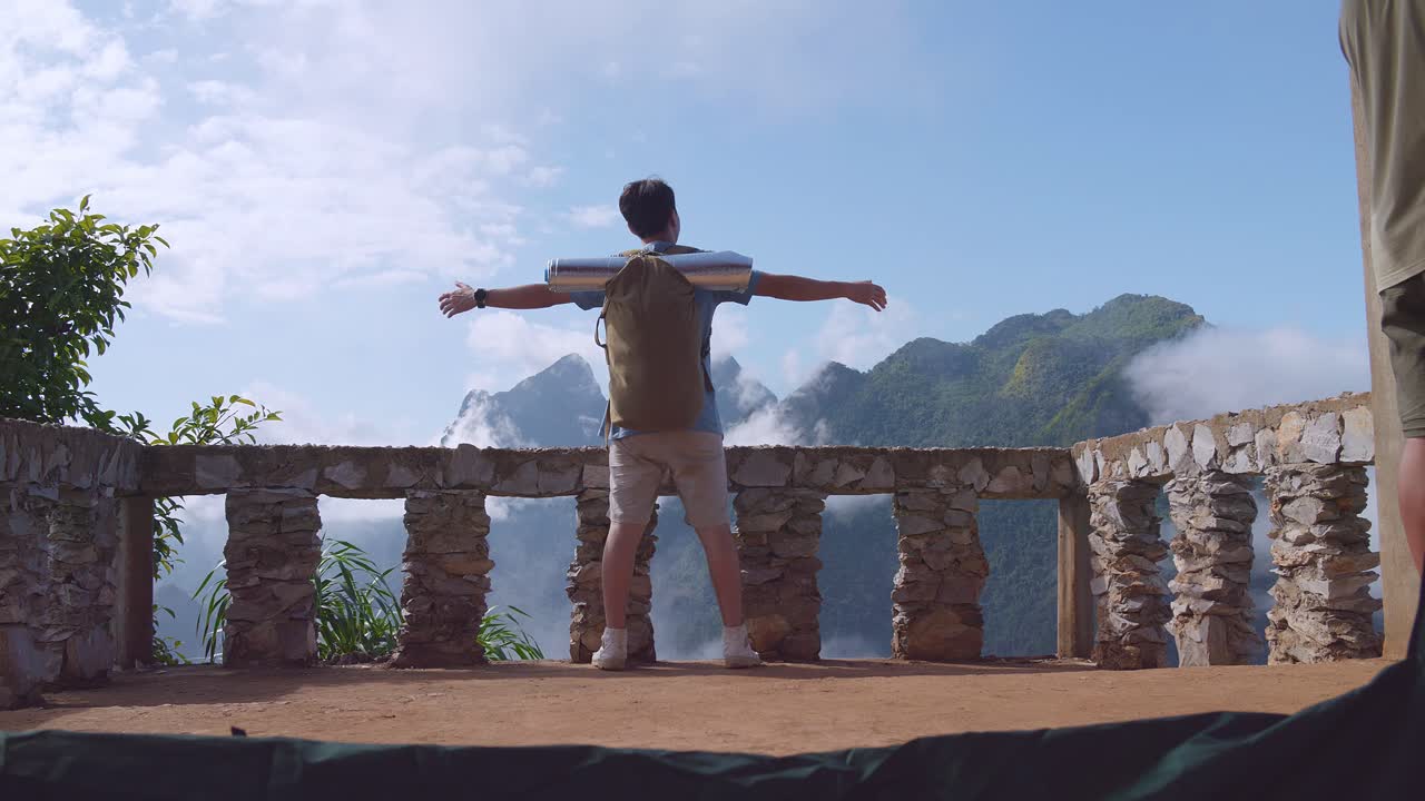 베란다 절벽 위에 서서 손을 들고 축하하는 아시아 하이커 남성, 안개 산의 꼭대기에 도달합니다.