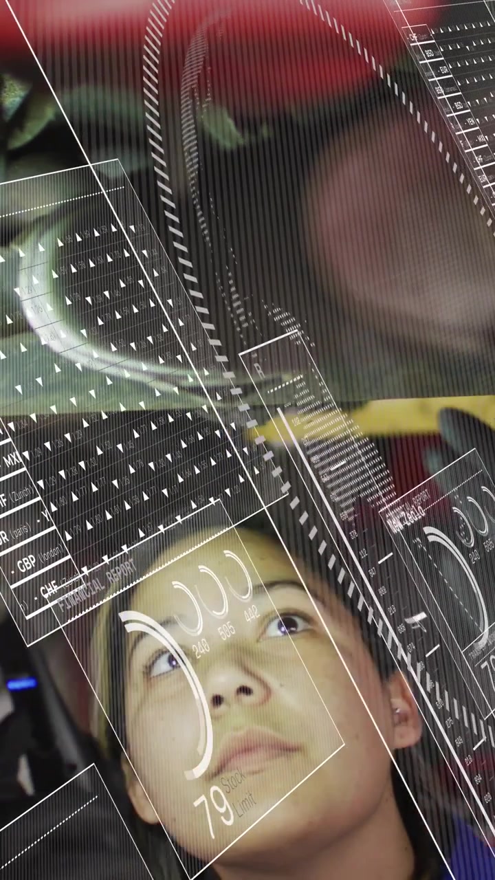 Vertical video: Tech doing check under car in auto shop, HUD updating as LED lighting part for test