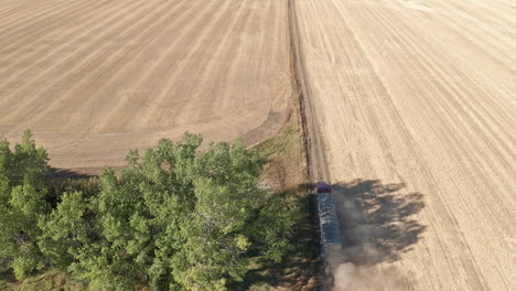 semi truck traveling crossing a boundless field terrain during sunny day