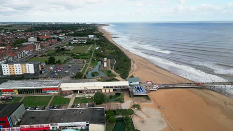 Typischer-Englischer-Badeort,-Aufgenommen-Mit-Einer-Drohne,-Die-Einen-Hohen-Luftbildpunkt-Bietet,-Der-Einen-Weiten-Sandstrand-Mit-Einem-Pier-Und-Tosenden-Wellen-Zeigt-4