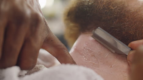 afeitarse el cuello con una navaja recta en la barbería