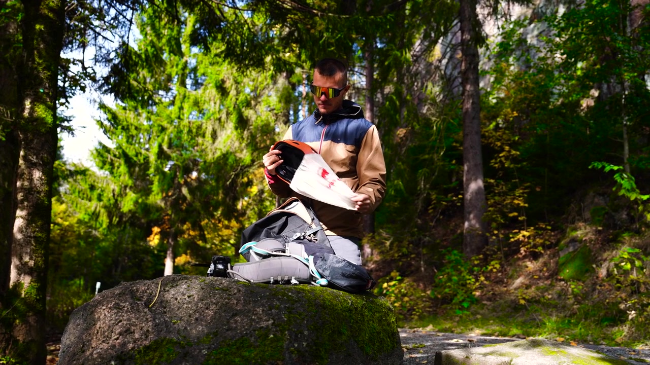 Male remove rock climbing helmet from bag, countryside forest in Czechia