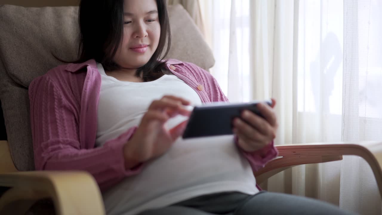 행복한 임신한 여성과 집에서 아기를 기대하고 있습니다.