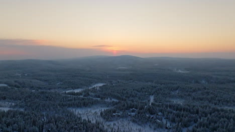 wide aerial overview of frosty nature with mountain background, sunset in lapland